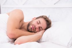 Man in bed, going through stages of sleep in Vero Beach