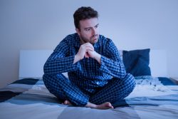 Man in pajamas, concerned about symptoms of sleep apnea in Vero Beach