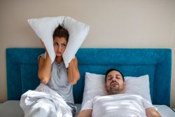 Couple in bed, husband needs tips to stop snoring in Vero Beach