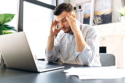 Tired man sitting at desk, may have sleep apnea in Vero Beach