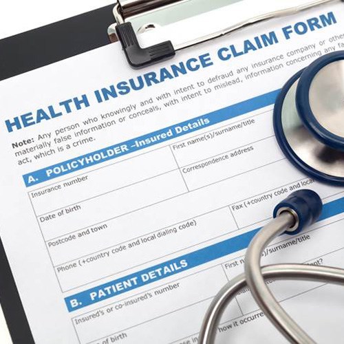 Health insurance claim form on clipboard, under stethoscope