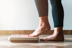 Person stepping on scale to check their weight