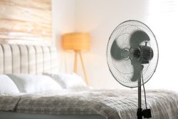 Bedroom with fan set up next to bed