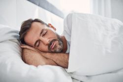 Middle-aged man sleeping peacefully in bed