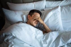 Exhausted man lying in bed