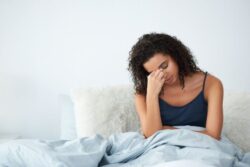 Tired woman sitting up in bed