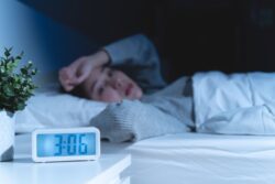 Woman awake in bed in the middle of the night, experiencing anxiety