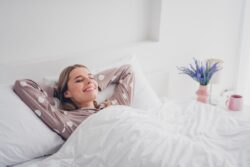 Woman smiling as she relaxes in comfy bed